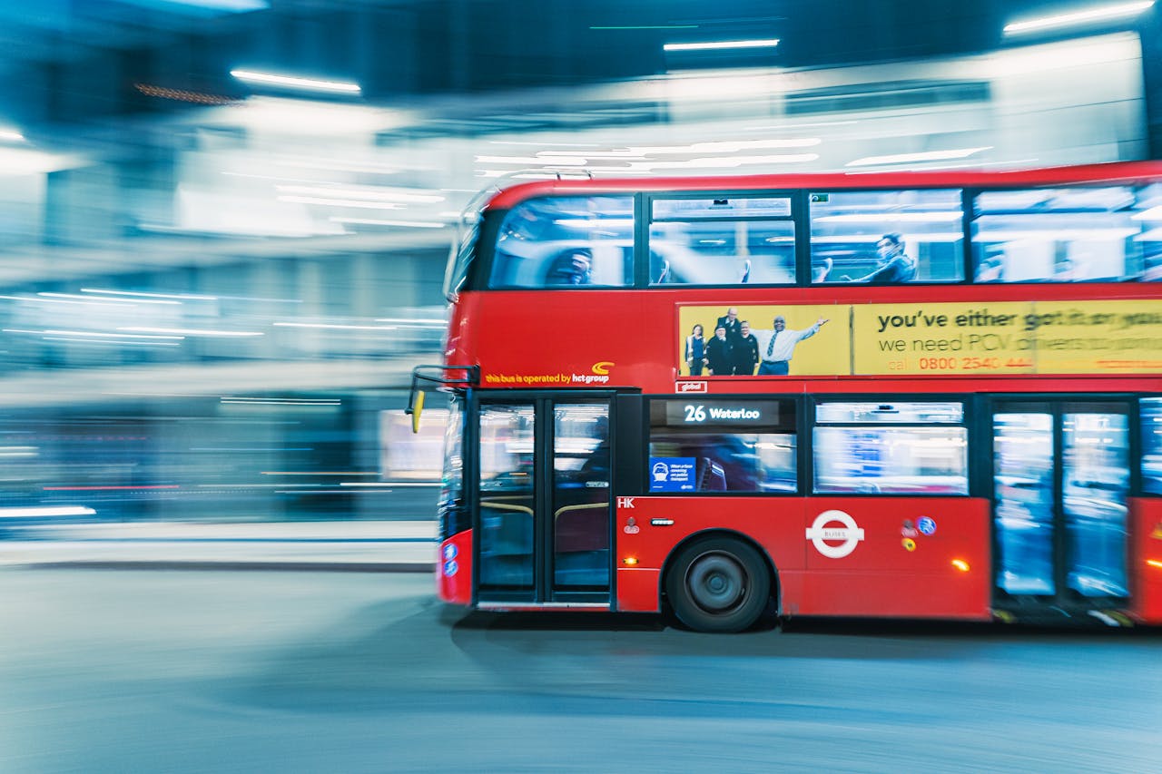 why-choose-us Blurred long exposure of traditional red double decker bus in London, capturing motion and urban energy.